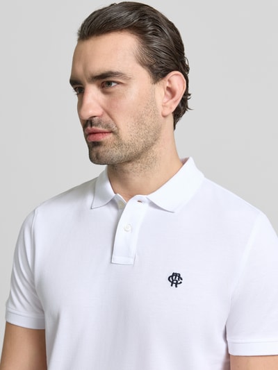 Männermodel trägt Slim Fit Poloshirt mit Logo-Stitching von MCNEAL in Weiß, reine Baumwolle, Polokragen, Nahaufnahme Oberkörper.