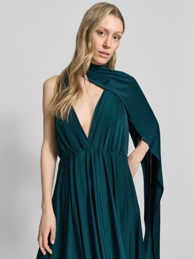 Frauenmodel trägt Knielanges Cocktailkleid mit tiefem V-Ausschnitt von Rose Avenue in Dunkelgrün, Taillierter Schnitt, Taillenband, Nahaufnahme Oberkörper.