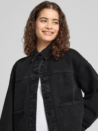 Frauenmodel trägt schwarze Jeansjacke mit aufgesetzten Taschen Modell 'KETTIE' von NOISY MAY, reine Baumwolle, Nahaufnahme Oberkörper.
