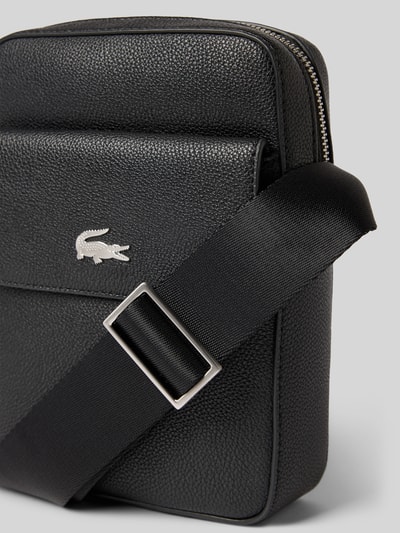 Produktfoto, Umhängetasche mit Label-Applikation von Lacoste aus schwarzem, genarbtem Leder, rechteckige Form, silberner Reißverschluss
