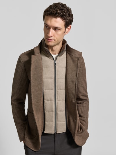 Männermodel trägt Slim Fit Sakko mit Woll-Anteil Modell 'Hypetar' von JOOP! COLLECTION in Braun, kombiniert mit heller Steppweste, Ganzkörperansicht von vorne.