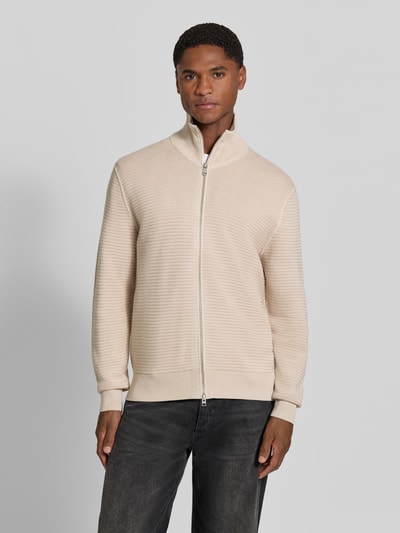 Męski model nosi Regular Fit Strickjacke aus reiner Baumwolle od Marc O'Polo, kolor jasny beż, tekstura prążkowana, sweter z bawełny, całkowity widok z przodu, sweter męski od Marc O'Polo.