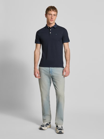 Männermodel trägt Straight Fit Jeans im 5-Pocket-Design Modell 'Chris' von JACK & JONES aus reiner Baumwolle, Ganzkörperansicht von vorne.