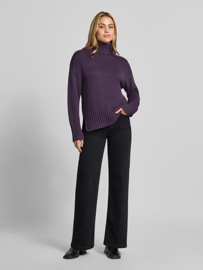 Frauenmodel trägt Relaxed Fit Strickpullover aus reiner Baumwolle mit Rollkragen von MOS MOSH in Lila, weiche Textur, elastische Abschlüsse, entspannte Passform, Ganzkörperansicht von vorne