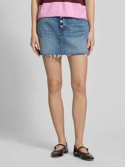 Frauenmodel trägt Mini-Jeansrock aus reiner Baumwolle Modell 'GALANIE_1_B' von Hugo Blue in Denim-Optik mit Nieten, Label-Patch, Logo-Stitching, Gürtelschlaufen, Kontrastnaht, Knopfleiste, offenem Saum, 5-Pocket-Design, schmaler Passform und Mini-Länge, Ganzkörperansicht von vorne.