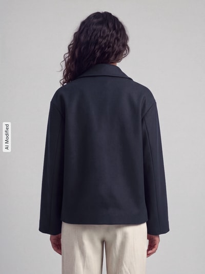 Kobiece modelka nosi płaszcz Regular Fit Mantel mit Reverskragen Modell 'NANCY' od ONLY, jednokolorowy, krój regular fit, kołnierz z połami, zapięcie na 2 guziki, długi rękaw, wpuszczane kieszenie boczne, wykończenie: polar, ujęcie całej sylwetki od tyłu, KI-modifiziertes Bild