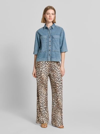 Frauenmodel trägt Relaxed Fit Hemdbluse in Denim-Optik von Emily Van den Bergh, reine Baumwolle, Halbarm, Brusttaschen, Ganzkörperansicht von vorne.