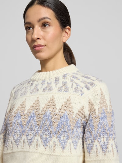Vrouwenmodel draagt Regular Fit Strickpullover aus Woll-Mix Modell 'FAROMBO' van BOSS Orange, Norwegerpatroon, crèmekleurig en blauw, gebreide textuur, label stitching, ronde hals, lange mouwen, ribboorden, Nahaufnahme bovenlichaam.