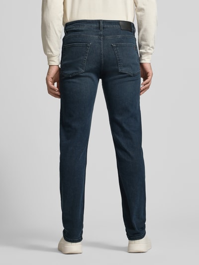 Męski model nosi Straight Fit Jeans aus Baumwoll-Mix Modell 'RE.MAINE BO S.AVE' od BOSS Orange, denim, 5 kieszeni, skórzana naszywka, proste nogawki, widok całej sylwetki od tyłu.