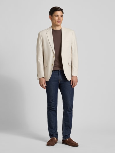 Männermodel trägt Sakko aus Leinen-Mix mit Pattentaschen von Christian Berg Men in Beige, kombiniert mit Jeans und braunem Shirt, Ganzkörperansicht von vorne, Regular Fit, Reverskragen, Knopfverschluss, Leinen-Anteil, Brustleistentasche, Rückenlänge 74 cm, Schulterbreite 46 cm, Ärmellänge 65 cm