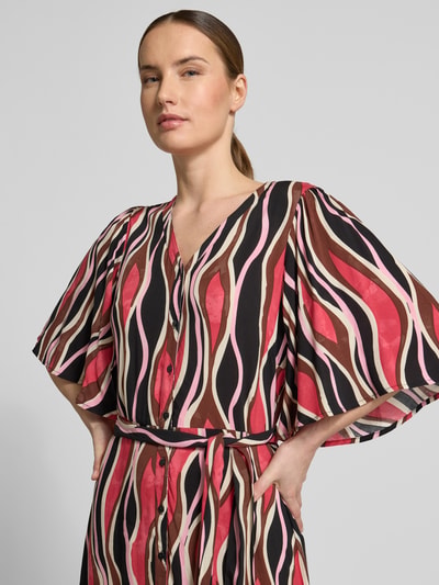 Vrouwenmodel draagt Regular Fit midi-jurk uit zuiver viscose model 'Cammi' van Soyaconcept met V-hals, halflange mouwen, getailleerde pasvorm, afneembare stoffen band en doorlopende knoopsluiting, kleurrijk golvend patroon, context: dames midi-jurk van zuiver viscose, Regular fit, ruglengte maat S 124 cm, borstwijdte 50 cm, mouwlengte 37 cm, Nahaufnahme bovenlichaam.