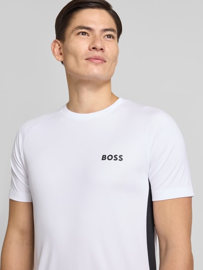 Männermodel trägt Slim Fit T-Shirt mit Label Print Modell 'TOP SPIN CB' von BOSS Green in Optik: Unifarben, Nahaufnahme Oberkörper.