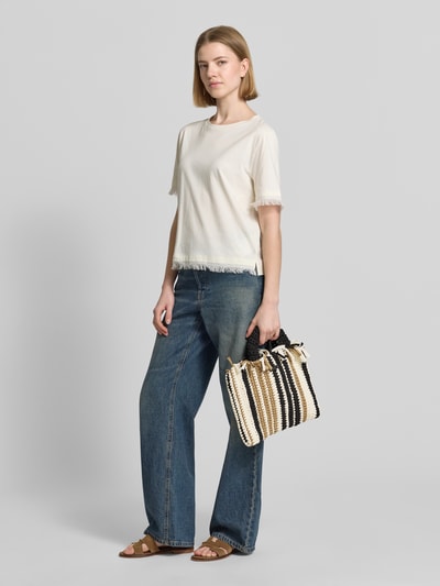 Frauenmodel trägt Handtasche mit Tragehenkel Modell 'Soothe' von Barts aus reiner Baumwolle, gestreift, Ganzkörperansicht von vorne. Hauptfach mit Magnetverschluss, Schulterriemen 26 cm, Größe 30x27x3 cm.