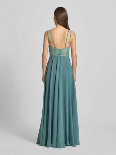 Modelka kobieca ma na sobie "Abendkleid mit Herz-Ausschnitt" od Jake*s Cocktail, krój slim fit, cekinowe zdobienia, plecy zakryte, widok całej sylwetki z tyłu.