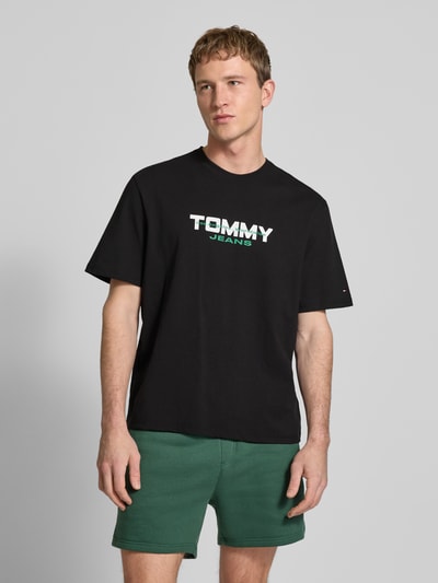 Männermodel trägt Regular Fit T-Shirt aus reiner Baumwolle von Tommy Jeans, Optik: Unifarben, Label-Schriftzug, Ganzkörperansicht von vorne.