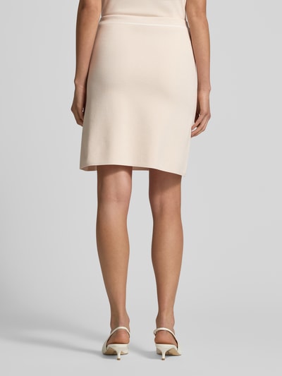 Vrouwenmodel draagt Knielanger Rok uit viscosemix van Marc Cain in lichtbeige, lichte A-lijn, logodetail, knielengte, bandwijdte 38 cm, totale lengte 50 cm, ganzkörperansicht rückansicht.