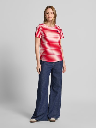 Frauenmodel trägt T-Shirt mit Motiv-Stitching und Rundhalsausschnitt von FREE/QUENT, rote und weiße Streifen, reine Baumwolle, gerader Schnitt, Ganzkörperansicht von vorne.