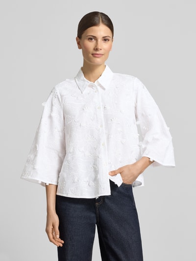 Frauenmodel trägt Regular Fit Bluse mit Stitchings Modell 'MAMICO' von EMME aus reiner Baumwolle, weiß, Hemdblusenkragen, Knopfleiste, 3/4-Arm, Struktur mit floralen Mustern, glatte Textur, Ganzkörperansicht von vorne. Rückenlänge 56 cm, Brustweite 46 cm, Ärmellänge 46 cm bei Größe 36.