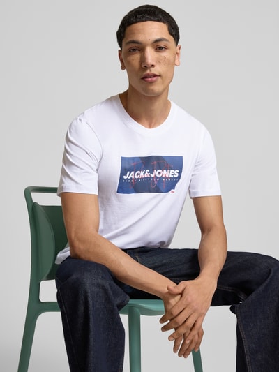 Männermodel trägt Regular Fit T-Shirt aus reiner Baumwolle Modell 'COLE' von Jack & Jones, weiß mit Label-Print, Nahaufnahme Oberkörper. Herren T-Shirt, Rundhalsausschnitt, Rückenlänge bei Größe M: 70 cm.