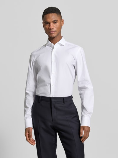 Męski model nosi Slim Fit Freizeithemd aus reiner Baumwolle od BOSS w kolorze białym, efekt: jednolity kolor, popelina, wzór na całej powierzchni, kołnierzyk typu cutaway, długi rękaw, mankiety kombi, zaokrąglone wykończenie, pas na plecach, koszula casualowa, wykończenie materiału: czysta bawełna; Ganzkörperansicht von vorne.
