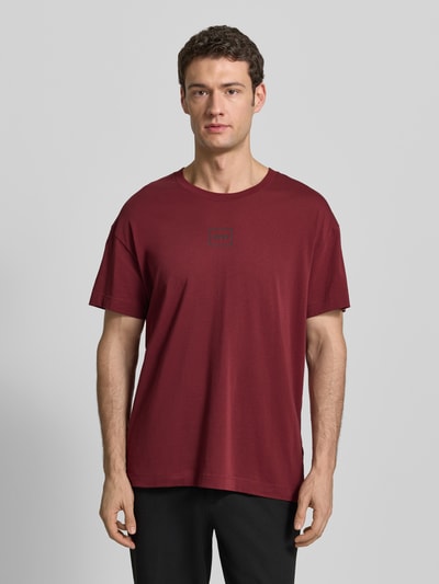 Männermodel trägt Relaxed Fit T-Shirt aus Baumwoll-Mix Modell 'LAZE' von HUGO, Optik: Unifarben, Label-Print, Rundhals, Ganzkörperansicht von vorne.
