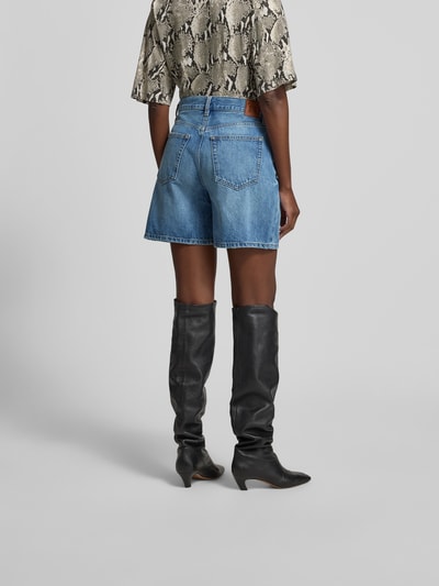 Frauenmodel trägt Jeansshorts aus reiner Baumwolle von Anine Bing in A-Linie mit 5-Pocket-Design, Kontrast-Nähte, Ganzkörperansicht Rückansicht.