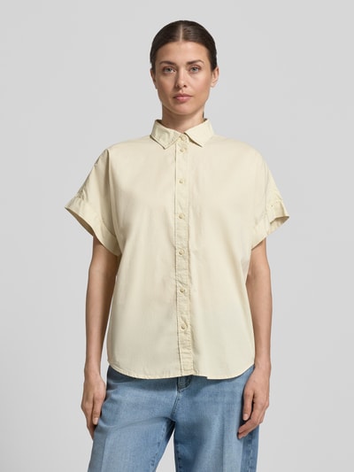 Modelka kobieca nosi Regular Fit Hemdbluse mit Hemdblusenkragen Modell 'Isabel' od ECOALF, czysta bawełna, kremowy kolor, krótki rękaw, zapięcie na guziki, długość tyłu 74 cm, długość rękawa 16 cm, widok całej sylwetki z przodu.