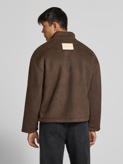 Männermodel trägt braune Fleecejacke mit Label-Stitching und Zweiwege-Reißverschluss von ANOTHER COTTON LAB, Material-Mix, Rückenansicht.
