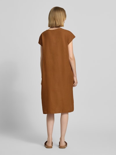 Frauenmodel trägt Knielanges Leinenkleid mit V-Ausschnitt Modell 'Ina' von Soyaconcept im Leinen-Mix mit Viskose-Anteil, Loose-Fit, einfarbig braun, Struktur matt, Ganzkörperansicht Rückansicht.