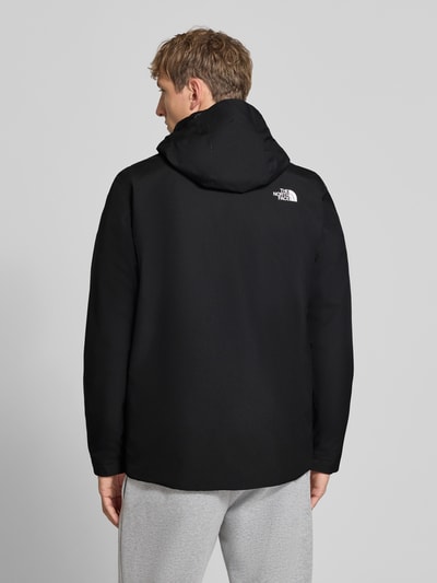 Männermodel trägt Jacke mit Label-Print von The North Face in Schwarz, glatte Struktur, Rückenansicht, gerade Passform, Ganzkörperansicht Rückansicht