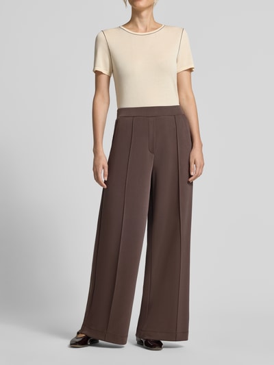 Vrouwenmodel draagt Wide Fit broek met viscose van comma, elastische materiaalmix, sierstrik, bandwijdte maat 36 37 cm, binnenbeenlengte 77 cm, frontale lichaamsopname