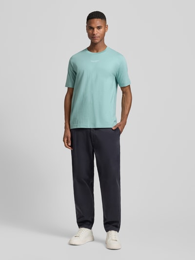 Männermodel trägt Regular Fit T-Shirt aus reiner Baumwolle von Marc O'Polo in Mintgrün, unifarben, Label Print, Ganzkörperansicht von vorne.