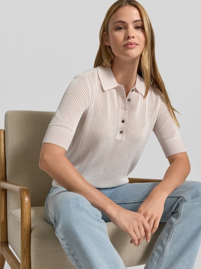 Frauenmodel trägt Lochstrick-Poloshirt - curated by Mary Braun von Style Icon Collection, Strick-Optik, Slim-Fit, Semitransparent, Polokragen, Kurzärmelig, Rückenlänge 57 cm, Ärmellänge 27 cm, helle Töne, klare Strickstruktur, weiche Haptik; Nahaufnahme Oberkörper.