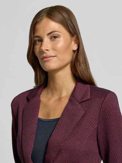 Vrouwenmodel draagt blazer met structuurpatroon van elastische materiaalmix met viscose, Model 'Kate' van ICHI, getailleerd, reverskraag, paspelzakken, knoopsluiting, donkerrood met zwart, Nahaufnahme Oberkörper.