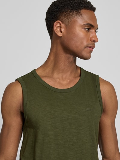 Männermodel trägt Regular Fit Tank Top aus reiner Baumwolle von s.Oliver RED LABEL in Olivgrün, Flammgarn, Label Print, Nahaufnahme Oberkörper.
