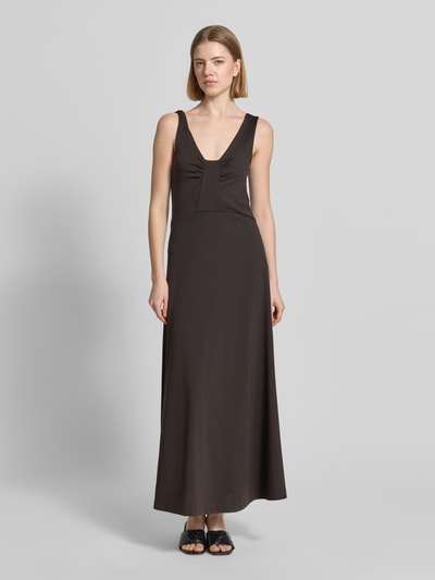 Frauenmodel trägt Maxikleid mit tiefem Rückenausschnitt Modell 'KLEALI' von Drykorn aus Lyocell-Mix mit Stretch-Anteil, taillierter Schnitt, V-Ausschnitt, breite Träger, einfarbig dunkelbraun, glatte Textur, Ganzkörperansicht von vorne.