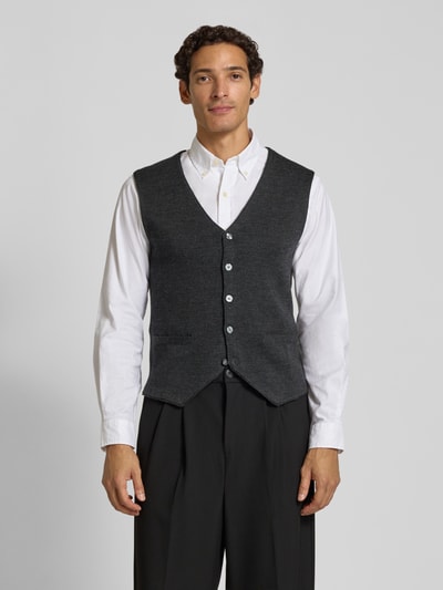 Männermodel trägt Slim Fit Weste aus Woll-Mix von Christian Berg Men in Dunkelgrau, Strick-Optik, Knopfleiste, V-Ausschnitt, Ganzkörperansicht von vorne.