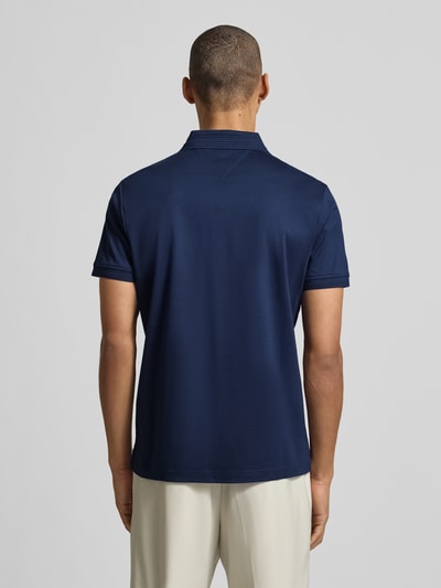 Männermodel trägt Regular Fit Poloshirt aus reiner Baumwolle von Tommy Hilfiger, unifarben, Polokragen, Ganzkörperansicht Rückansicht.