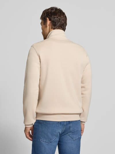 Männermodel trägt Regular Fit Sweatjacke aus Baumwoll-Mix von s.Oliver RED LABEL in Beige, glatte Textur, blaue Jeans, Ganzkörperansicht Rückansicht.