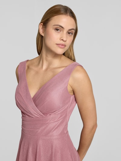 Frauenmodel trägt knielanges Cocktailkleid mit V-Ausschnitt von TROYDEN COLLECTION aus Chiffon, taillierter Schnitt, Breite Träger, Nahaufnahme Oberkörper. Brillanter, zart glänzender Stoff, elegante Textur, Rückenlänge bei Größe 36: 85 cm, Brustweite: 43 cm, rückseitiger V-Ausschnitt und Rückenreißverschluss.