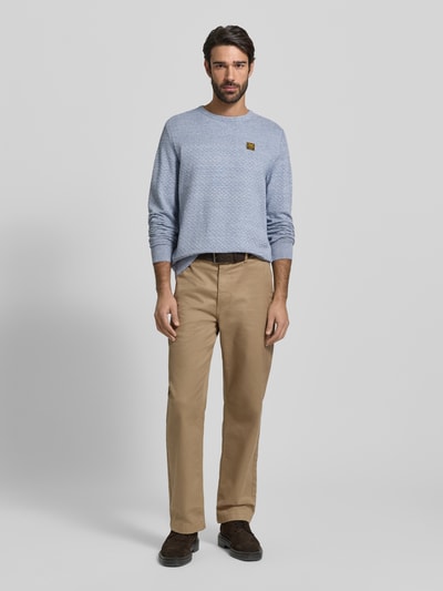 Männermodel trägt Strickpullover mit gerippten Abschlüssen von PME Legend aus reiner Baumwolle, Regular-Fit, Rundhalsausschnitt, Label-Detail, Hellblau, feine Strickstruktur, Beige Hose, Braun Schuhe, Ganzkörperansicht von vorne.