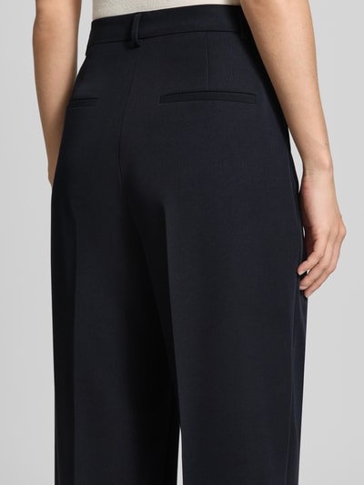 Frauenmodel trägt dunkelblaue Weite Hose mit Viskose-Anteil von Jake*s Collection, glatte Textur, Detailaufnahme Rückansicht.