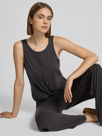 Frauenmodel trägt Regular Fit Top aus Viskose-Mix Modell 'ANORA' von PIECES, dunkler Farbton, glatte Struktur, Nahaufnahme Oberkörper.