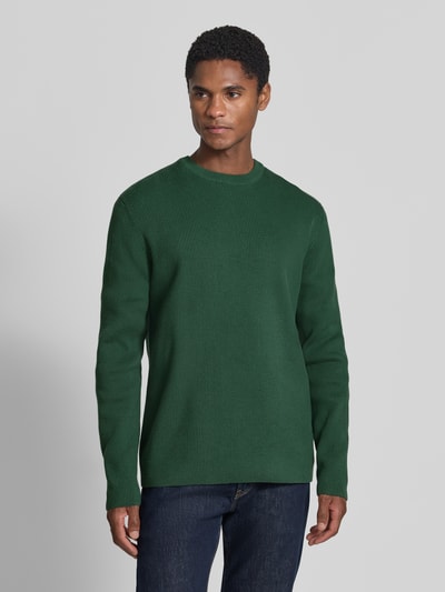 Männermodel trägt Slim Fit Strickpullover Baumwoll-Mix von Lindbergh, grün, gerippte Optik, Rundhalsausschnitt, Ganzkörperansicht von vorne.