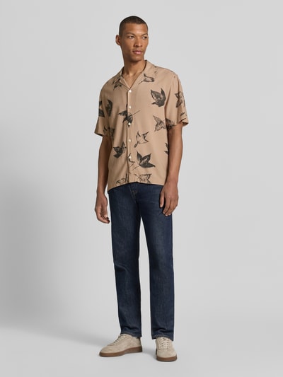 Männermodel trägt Regular Fit Freizeithemd aus reiner Viskose Modell 'TERRY' von SELECTED HOMME in Beige mit Blattmuster, Ganzkörperansicht von vorne. Herren Freizeithemd.