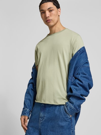 Männermodel trägt T-Shirt mit Rundhalsausschnitt von Filippa K in Hellgrün, reine Baumwolle, Regular Fit, Nahaufnahme Oberkörper.