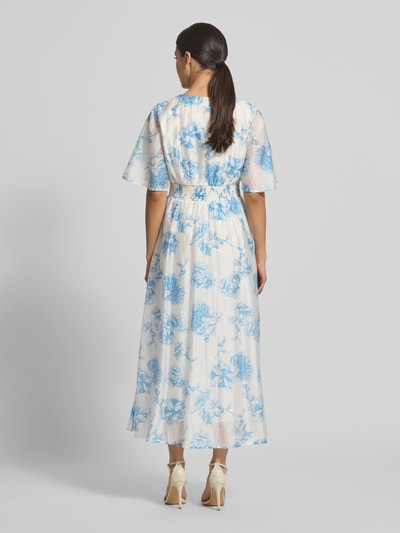 Frauenmodel trägt Damen Midikleid aus Lyocell-Mix Modell 'Evangelia' von MSCH Copenhagen, Allover-Look in Weiß mit blauen Blumen, Taillierter Schnitt, V-Ausschnitt, Rückenlänge 131 cm, Brustweite 41 cm, Ärmellänge 31 cm, Ganzkörperansicht Rückansicht.