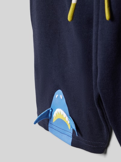Produktfoto, Shorts mit Motiv-Print und elastischem Bund von Blue Seven in Dunkelblau, Detailansicht mit Hai-Motiv, Reine Baumwolle, Regular-Fit, Motiv-Print, elastischer Bund, Bundweite bei Größe 116: 27 cm, Innenbeinlänge bei Größe 116: 10 cm