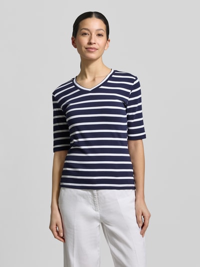 Kobiece modelka nosi T-shirt mit Streifenmuster und V-Ausschnitt od Christian Berg Woman, mieszanka bawełny i elastanu, krój regular fit, dekolt w serek, długość tyłu w rozmiarze S: 55 cm, widok całej sylwetki z przodu