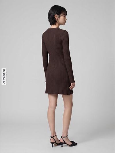 Frauenmodel trägt eng anliegendes Freizeitkleid aus Viskose-Mix Modell 'MICHELLA' von ONLY in Dunkelbraun, feine Rippstruktur, Ganzkörperansicht Rückansicht, KI-modifiziertes Bild. Damen Strickkleid von ONLY.